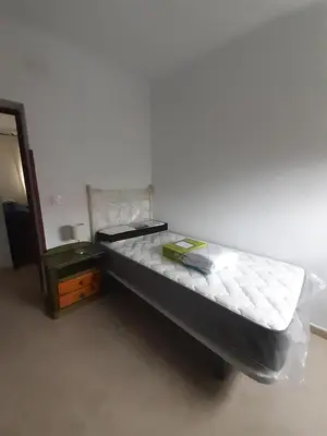 a small bed in a room with a night stand at Granadina 4 in Jerez de la Frontera
