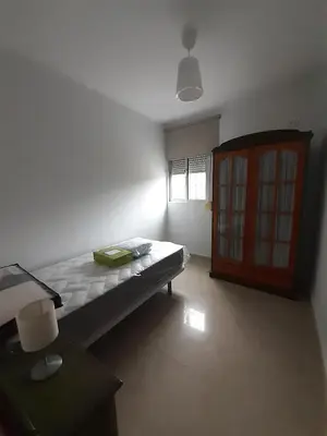 a bedroom with a bed and a wooden door at Granadina 4 in Jerez de la Frontera