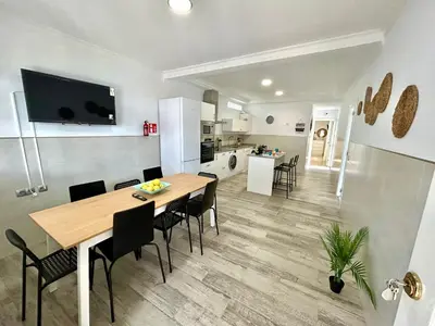 a kitchen and dining room with a table and chairs at GATU Villa Serena piscina privada mayores de 25 años y familias in Chiclana de la Frontera