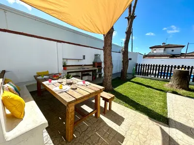 a patio with a table and a bench and a building at GATU Villa Serena piscina privada mayores de 25 años y familias in Chiclana de la Frontera