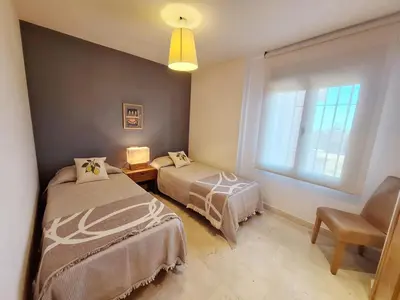 a bedroom with a bed with pillows and two lamps at Elegante y lujoso en Sancti Petri in Novo Sancti Petri