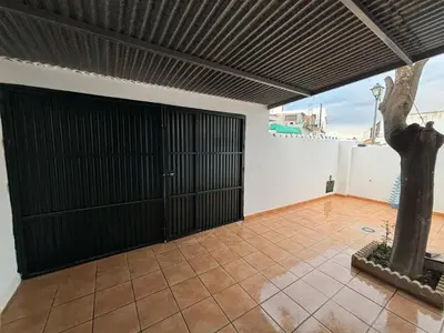 a garage with black doors and a tile floor at Casita de Don Juan Tenorio in Torrecera
