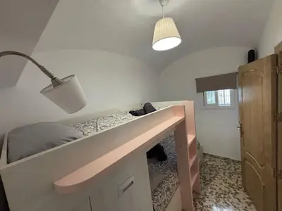 a bedroom with a bed with a desk and a lamp at Casita de Don Juan Tenorio in Torrecera