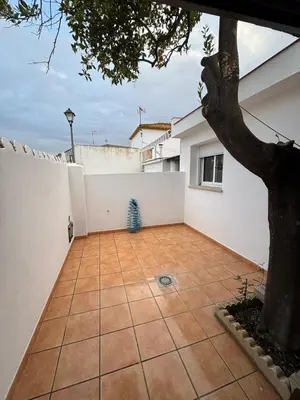 a courtyard with a tree and a white wall at Casita de Don Juan Tenorio in Torrecera