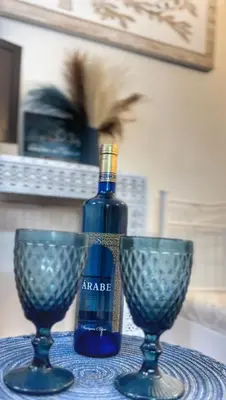 a bottle of wine and two wine glasses on a table at Casa arabe in Alcalá de los Gazules