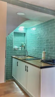 a kitchen with a sink and a blue tile wall at Casa arabe in Alcalá de los Gazules