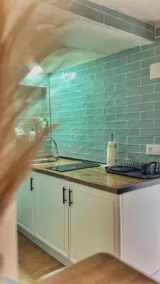 a kitchen with a sink and a blue tile wall at Casa arabe in Alcalá de los Gazules