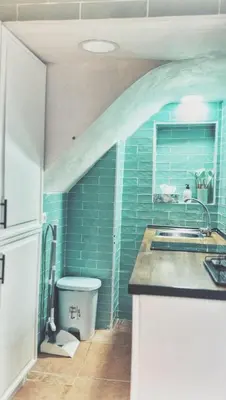 a kitchen with a sink and a blue tile wall at Casa arabe in Alcalá de los Gazules