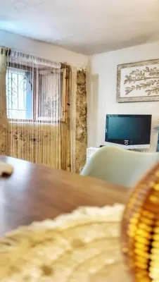 a living room with a table and a couch and a television at Casa arabe in Alcalá de los Gazules