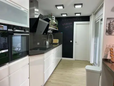 a kitchen with white cabinets and a black wall at Jerez Deluxe in Jerez de la Frontera