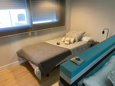a small bedroom with a bed and a window at Jerez Deluxe in Jerez de la Frontera