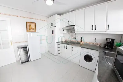a kitchen with white cabinets and a washer and dryer at Villa La Marea in Chiclana de la Frontera
