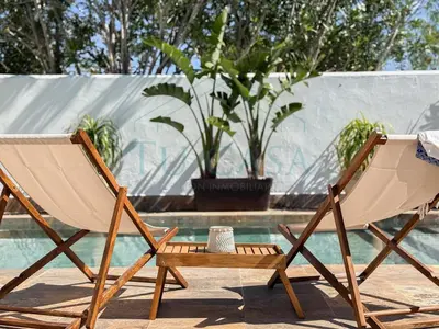 a couple of chairs sitting next to a pool at Villa La Marea in Chiclana de la Frontera