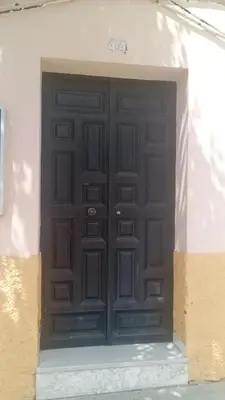 a large black door on a white building at Apartamento B&A in El Cuervo