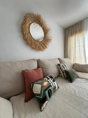 a living room with a couch with a mirror on the wall at Apartamento Sanlúcar PARKING GRATIS ,PISCINA ,WIFI ATICO con vistas in Sanlúcar de Barrameda