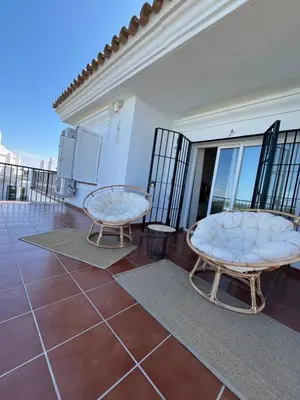 a balcony with two chairs on top of a building at Apartamento Sanlúcar PARKING GRATIS ,PISCINA ,WIFI ATICO con vistas in Sanlúcar de Barrameda