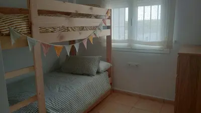 a bedroom with two bunk beds and a window at Apartamento Sanlúcar PARKING GRATIS ,PISCINA ,WIFI ATICO con vistas in Sanlúcar de Barrameda