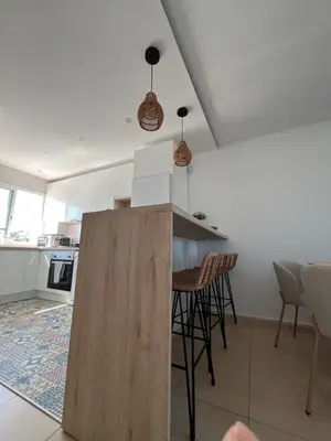 a kitchen with a counter and chairs in a room at Apartamento Sanlúcar PARKING GRATIS ,PISCINA ,WIFI ATICO con vistas in Sanlúcar de Barrameda