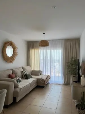 a living room with a couch and a large window at Apartamento Sanlúcar PARKING GRATIS ,PISCINA ,WIFI ATICO con vistas in Sanlúcar de Barrameda
