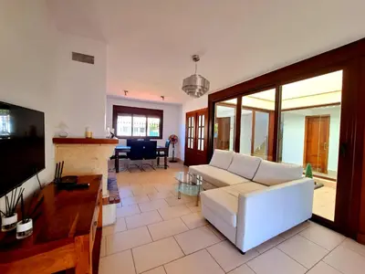 a living room with a white couch and a tv at Chalet Loma de Sanctipetri in Chiclana de la Frontera