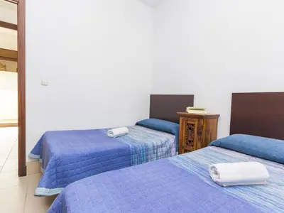 a room with two beds with blue comforters at Chalet Loma de Sanctipetri in Chiclana de la Frontera