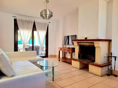 a living room with a couch and a fireplace at Chalet Loma de Sanctipetri in Chiclana de la Frontera