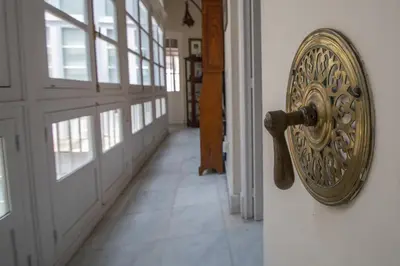 an open door with a metal door knocker on a wall at La Casa de los Girasoles in Cádiz