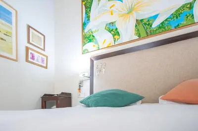 a bedroom with a bed with a green pillow at La Casa de los Girasoles in Cádiz