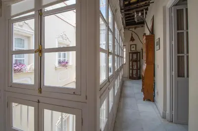 a hallway with doors and windows in a building at La Casa de los Girasoles in Cádiz