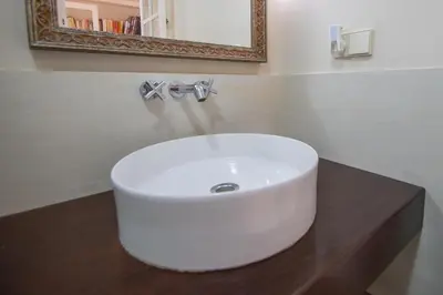 a white sink in a bathroom with a mirror at La Casa de los Girasoles in Cádiz