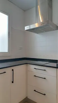 a black refrigerator in a kitchen with a laptop at Sherryflat Prieta 7 in Jerez de la Frontera