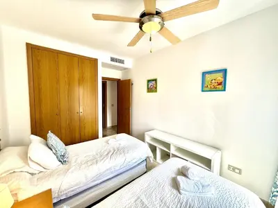 a bedroom with two beds and a ceiling fan at Atardecer dorado free parking by staycare in Chipiona