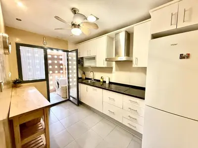 a kitchen with white cabinets and a ceiling fan at Atardecer dorado free parking by staycare in Chipiona