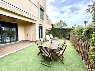 a patio with a table and chairs on the grass at Atardecer dorado free parking by staycare in Chipiona