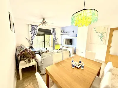 a living room with a table and a couch at Atardecer dorado free parking by staycare in Chipiona