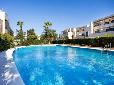 a large swimming pool in front of a building at Atardecer dorado free parking by staycare in Chipiona