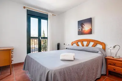 a bedroom with a bed and a large window at aldea 2 5 1ºB in Chiclana de la Frontera