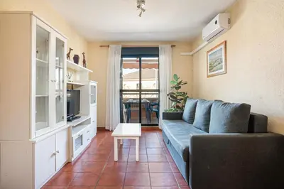 a living room with a blue couch and a table at aldea 2 5 1ºB in Chiclana de la Frontera