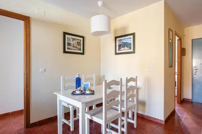 a dining room with a white table and chairs at aldea 2 5 1ºB in Chiclana de la Frontera