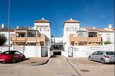 two cars parked in a parking lot in front of a building at aldea 2 5 1ºB in Chiclana de la Frontera