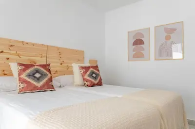 a white bed with two pillows on top of it at GINVA - Apartamento en pleno centro 4 in El Puerto de Santa María