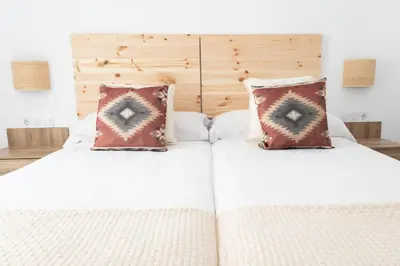 two beds with white sheets and pillows in a bedroom at GINVA - Apartamento en pleno centro 4 in El Puerto de Santa María