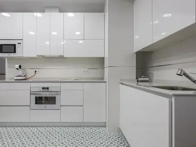 a white kitchen with white cabinets and a sink at Playa Caleta in Cádiz