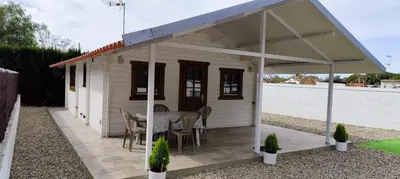 a small white shed with a table and chairs at Casa El Pinar in Conil de la Frontera