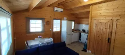 a small kitchen with a table and a refrigerator at Casa El Pinar in Conil de la Frontera