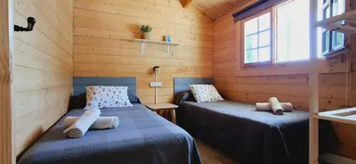 a room with two beds in a wooden cabin at Casa El Pinar in Conil de la Frontera