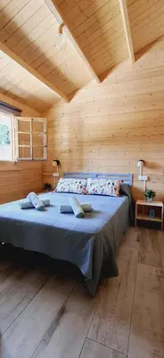 a bedroom with a large bed in a wooden room at Casa El Pinar in Conil de la Frontera