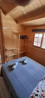 a bedroom with a bed in a wooden cabin at Casa El Pinar in Conil de la Frontera