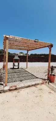 a wooden pavilion on the beach with a grill at Casa El Pinar in Conil de la Frontera