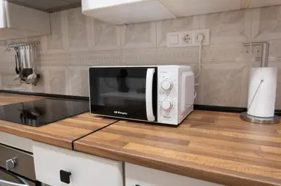 a microwave sitting on top of a counter in a kitchen at Apartalux Playa La Caleta in Cádiz